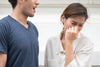 Woman Turning Away from Bad Breath as Man is Speaking to Her