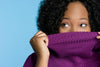Woman Holding Her Purple Turtleneck Over Her Mouth and Nose