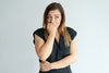 Woman Covering Her Mouth and Stomach Looking Concerned