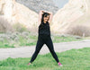 Woman in Black Workout Clothing Stretching Before Outdoor Workout