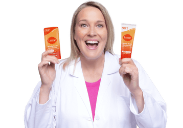 Dr. Shannon Klingman in a white lab coat, smiling with two Lume products