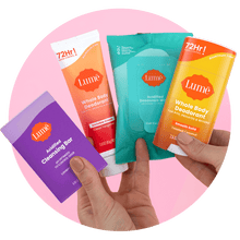 Hands holding four Lume products. Cleansing bar, cream tube deodorant, wipes, and solid stick deodorant