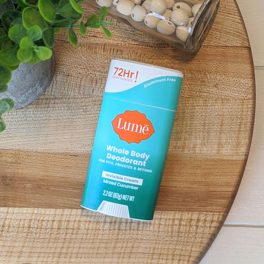 Lume Minted Cucumber Cream Deodorant Stick on a wooden cutting board